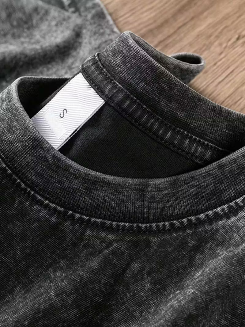 Close-up of a black t-shirt with a brand label on a wooden surface
