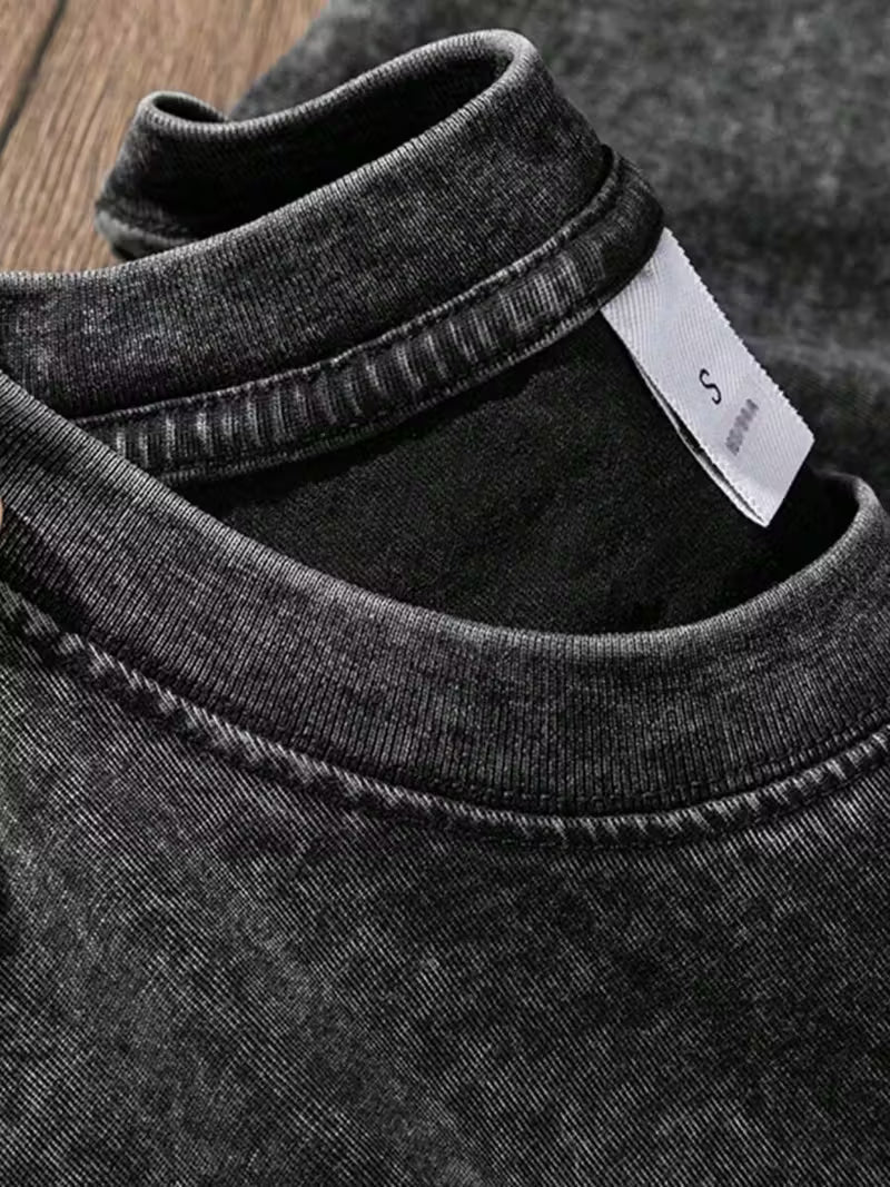 Close-up of a gray t-shirt with a brand label on a wooden surface