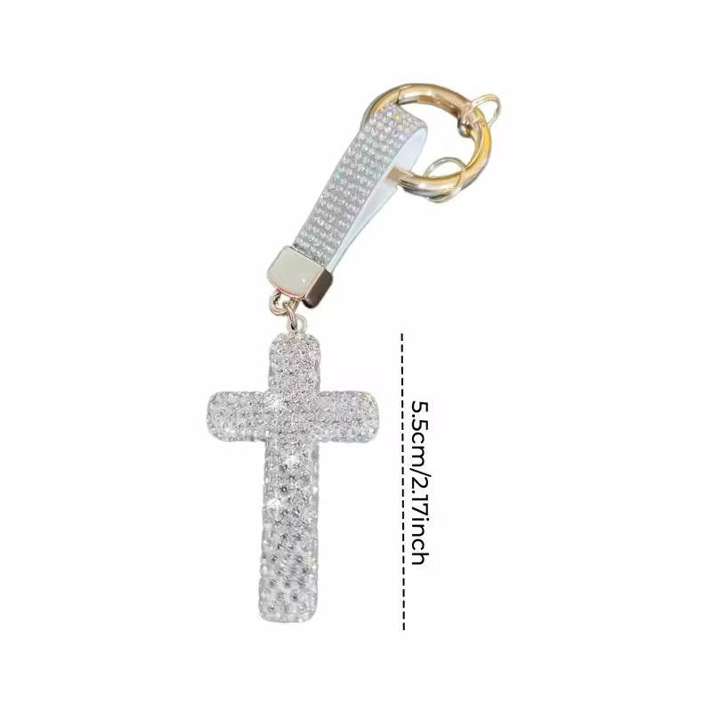 Cross-shaped keychain with glittery design on a white background